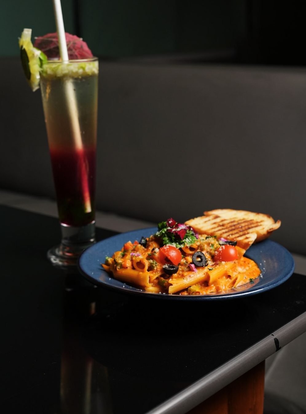 Penne with a toasted sandwich and a layered drink