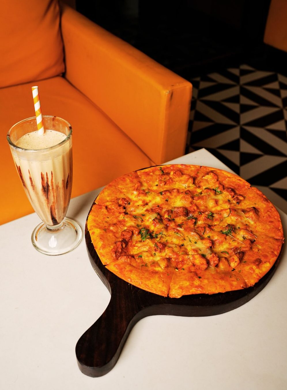 Pizza on a wooden board with a milkshake