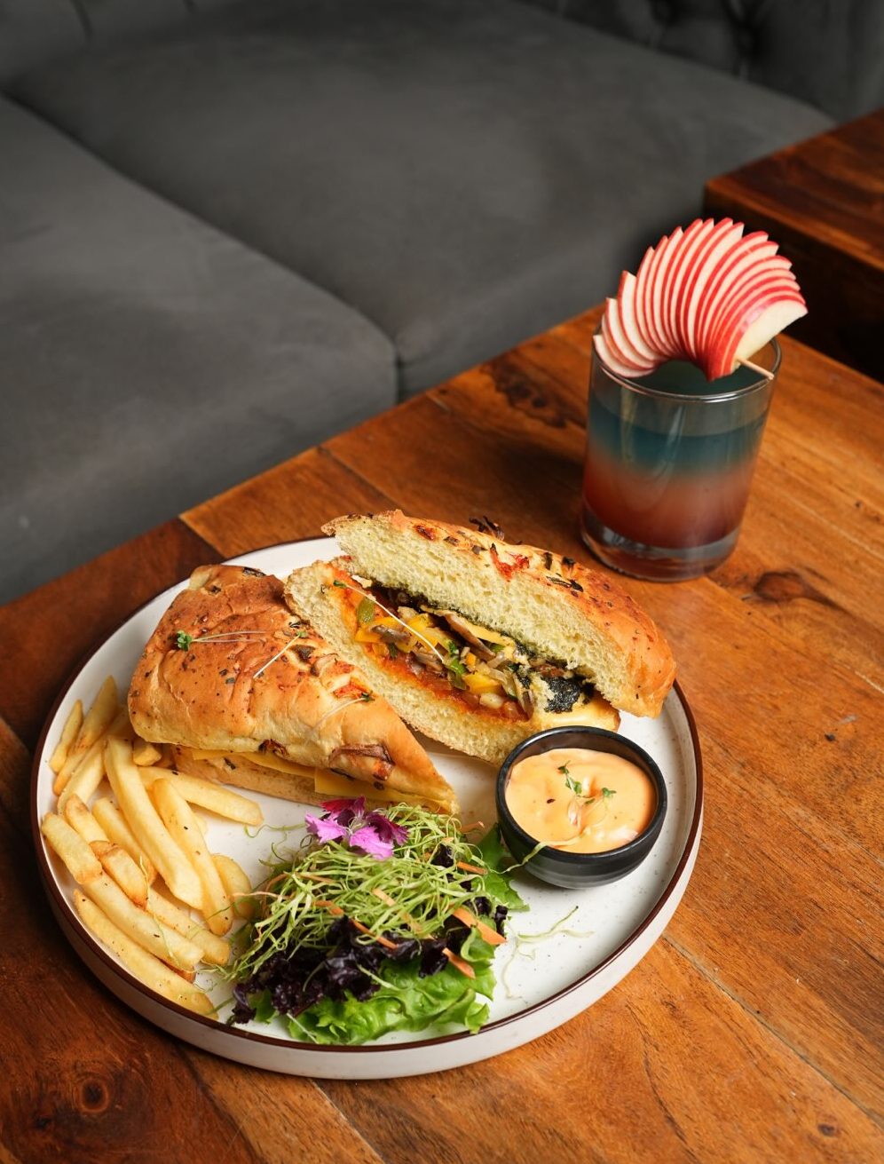 Sandwich with fries and salad on a wooden table